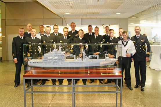 Mannschaft & Vereinsmitglieder stehen um ein Modellschiff der EGV-BONN